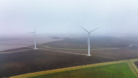 Drone-shot-of-a-wind-turbine-creating-clean-energy-in-foggy-rural-setting