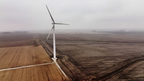 Drone-shot-of-a-wind-turbine-creating-clean-energy-in-foggy-rural-setting