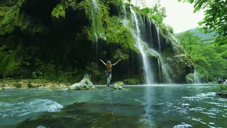 Glückliche-Touristin,-Die-Einen-Erstaunlichen-Wasserfall-Genießt