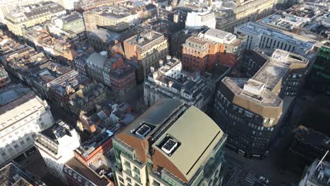 Aerial-drone-flight-over-Manchester-City-Centre-showing-the-gothic-rooftops-below