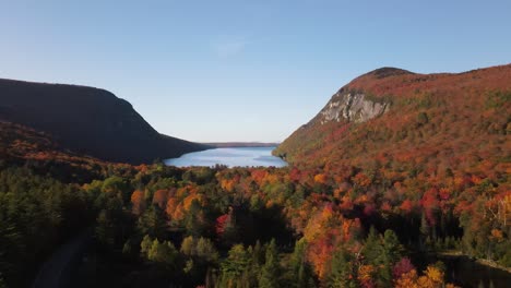 Beautiful-aerial-drone-footage-of-the-fall-leaves-on-and-around-Mount-Hor,-Mount-Pisgah,-and-Lake-Willoughby-during-peak-autumn-foliage-at-Willoughby-State-forest-in-Westmore,-Vermont