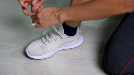 Putting-on-sport-shoes-before-a-workout,-tied-by-their-own-shoestrings