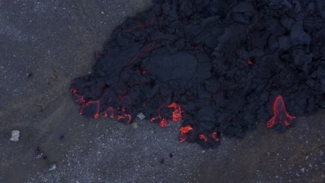 Top-down-of-local-tourist-people-standing-near-hot-sluggish-lava-field