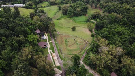 Aerial-bird's-eye-view-of-cottages-along-the-mountain-slope-in-Tham-Pla-Pha-Suea-National-Park,-nothern-Thailand-at-daytime