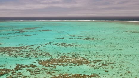 Low-and-fast-fly-over-shallow-blue-water-on-coral-reef-in-Tonga