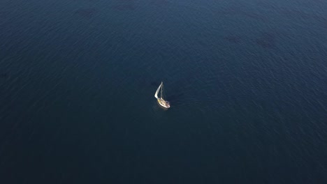 Drone-Rising-High-From-Sailing-Boat-Alone-In-Deep-Blue-Sea,-Cyprus