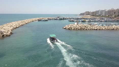 Areal-Shot-Of-Small-Fishing-Boat-Sailing-Towards-Mackenzie-Old-Port,-Larnaca-City