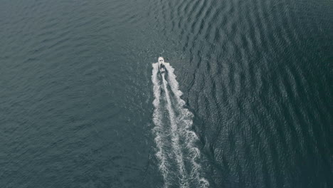 Aerial-shot-of-with-a-drone-following-a-boat-from-a-distance