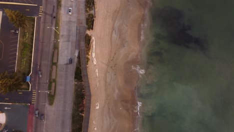 Top-down-aerial-view-of-beach-and-coastal-road