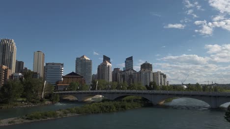 Stadtbrücken-Schwenken-über-Den-Fluss-Mit-Wolkenkratzern-An-Einem-Sonnigen-Tag-Calgary-Alberta-Kanada