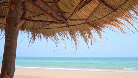 A-woven-beach-umbrella-shades-the-view-of-the-ocean-waves