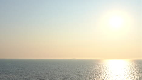 A-bright-tropical-sun-sits-on-the-horizon-shining-on-the-ocean-waves