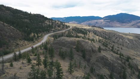 Highway-1-next-to-Kamloops-Lake-passes-through-mountains-with-spruce-and-pine-trees-in-the-desert-scenery-of-the-Okanagan-,-Nicola-Thompson-Region-in-BC-,-Canada