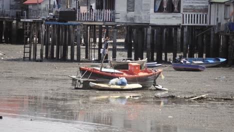 A-local-Thai-fisherman’s-boat-beached-on-the-sand-during-low-tide-in-Si-Rascha,-Thailand