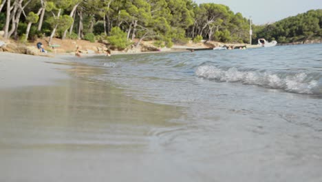 Sandstrand-Mit-Kleinen-Wellen-Und-Menschen-Im-Hintergrund-An-Der-Platja-De-Formentor-Mallorca-Palmen