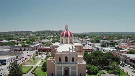 AERIAL---Church-and-park,-Montemorelos,-Nuevo-León,-Mexico,-rising-forward-reveal