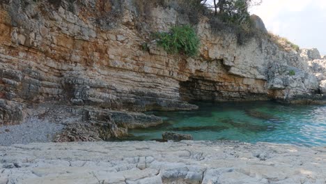 Bataria-beach,-Pristine-rocky-beach-with-Turquoise-clear-water,-Kassiopi,-Corfu-Island---Panning-shot