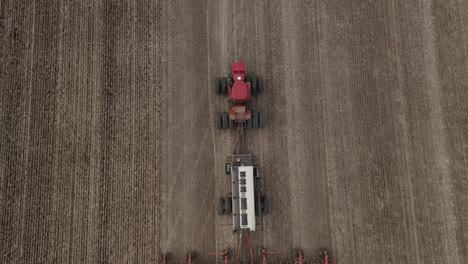 Tractor-and-seeder-plants-fertile-field,-Saskatchewan,-Canada