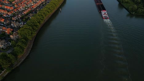 Aerial-Flying-Over-Beneden-Merwede-With-Veerhaven-Barge-Travelling-Along-It