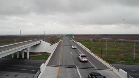AERIAL---Cars-on-highway-overpass,-cloudy-day,-Reynosa,-Tamaulipas,-Mexico,-forward