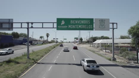 AERIAL---Road-sign-and-highway,-Montemorelos,-Nuevo-León,-Mexico,-reverse