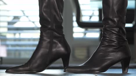 black-leather-boots-with-heels-tap-nervously-on-the-floor