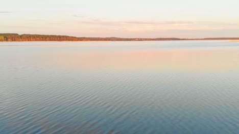 Scenic-golden-hour-ripples-of-Jugla-lake-Riga-Latvia-aerial