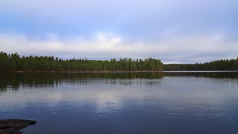 time-lapse-shot-over-a-large-lake-with-a-forest-on-the-opposite-shore