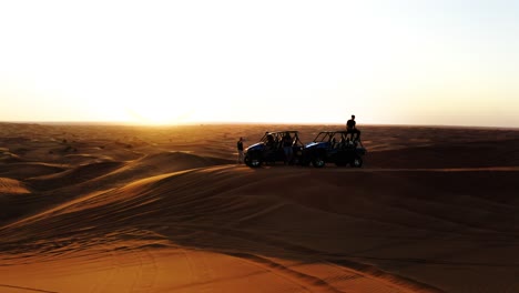 Aerial-Shot-Of-People-And-Buggy-Vehicles-On-Sand-Dunes-At-Sunset