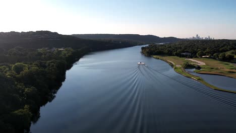 Aerial-drone-panning-shot-over-lake-Austin-in-Austin,-Texas,-USA-with-speed-boat-passing-by-at-daytime