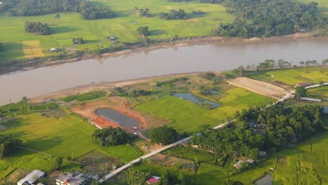 ascending-over-rural-village-to-reveal-rice-fields-on-the-far-bank-of-the-river