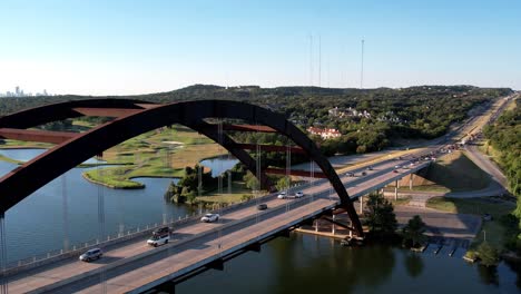 Aerial-drone-forward-moving-shot-over-Pennyback-bridge-in-Austin,-Texas,-USA-with-a-top-down-view-of-Lake-Austin-on-a-bright-sunny-day
