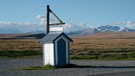 Static-shot-of-Irishman-Creek-station-hut-with-snow-capped-mountains-in-background-in-the-picturesque-Mackenzie,-New-Zealand