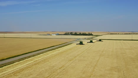 Tractores-En-El-Trabajo-Cosechando-Cultivos-En-Golden-Farm-Field-En-Saskatchewan,-Canadá
