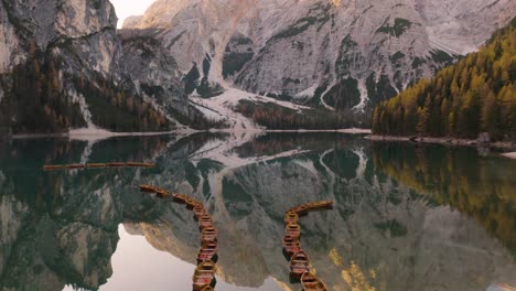 Cinematic-Drone-Flight-Over-Row-Boats-on-Lake-Braies,-Famous-Lake-in-Italian-Dolomites