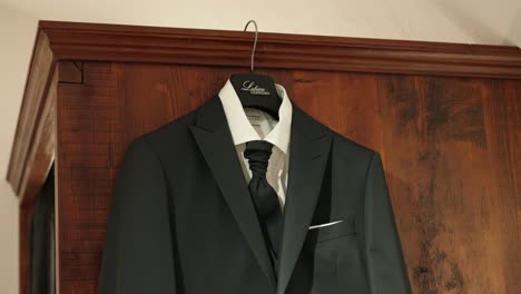 Schwarzer-Anzug,-Der-An-Einer-Braunen-Holzwand-Hängt