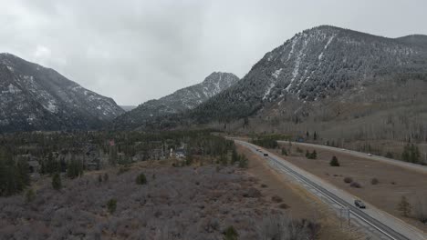Aerial-dolly-shot-following-along-Interstate-70-with-fresh-snow-on-distant-mountains
