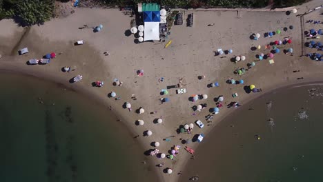 People-relaxing-on-Italy-sandy-coastline,-aerial-top-down-view