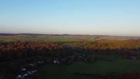 Herbstluftaufnahme-über-Die-Englische-Landschaft-Mit-Kleinem-Dorf-Und-Feldern-Und-Wäldern-Im-Goldenen-Stundenlicht---Drohnenaufnahme-In-Dorset,-Großbritannien-4k