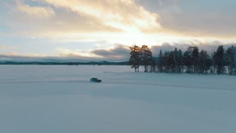 Aerial-view-Swedish-Norbotten-driver-drifting-frozen-Lapland-woodland-ice-lake-at-sunrise