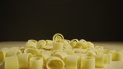 Macro-probe-lens-view-of-raw-pasta,-dolly-forward-through-pasta-ring