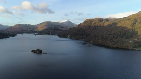 High-Aerial-Drone-Shot-over-Ullswater-Lake-with-Snowy-Helvellyn-Mountain-on-Sunny-and-Cloudy-Morning-Lake-District-Cumbria-United-Kingdom