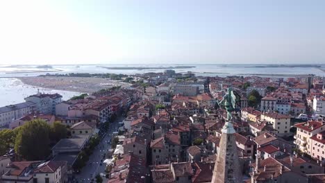 Cityscape-rooftops-and-Angel-Church-of-Grado-city-in-Italy,-aerial-drone-view