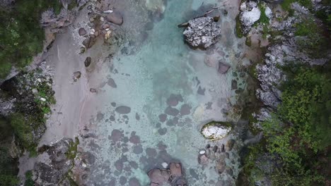 Crystal-clear-river-and-rocky-coastline-in-Dolomites,-top-down-view