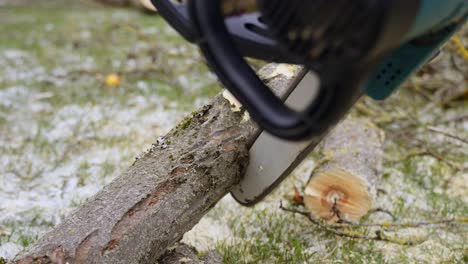 Using-chainsaw-to-cut-log-into-smaller-pieces,-close-up-view