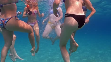 Unter-Wasser-Zeitlupenaufnahme-Einer-Gruppe-Von-Freundinnen,-Die-In-Kristallklarem-Meerwasser-Schwimmen