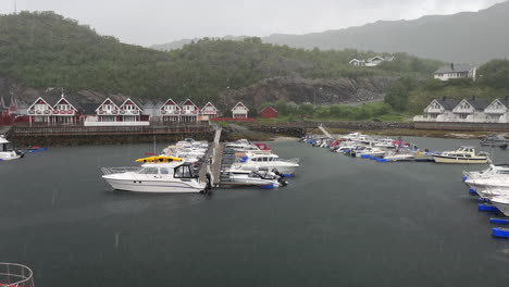 Static-shot-of-heavy-rain-pouring-down-in-a-Norwegian-harbor-during-summer-in-Nordland