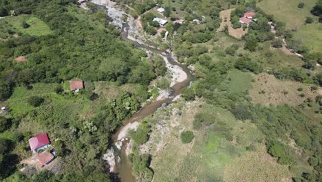 Aerial-view-of-an-area-near-a-river-with-rocky-areas-and-small-houses