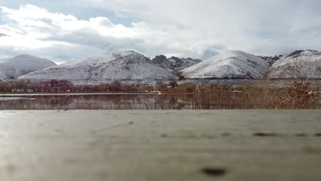 Vista-De-ángulo-Bajo-Del-Tranquilo-Lago-Diaz-Rodeado-De-Montañas-Cubiertas-De-Nieve-Durante-La-Nevada-Fresca