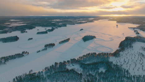 Golden-snowy-sunrise-long-shadows-across-Lapland-drifting-racetrack-panoramic-aerial-view